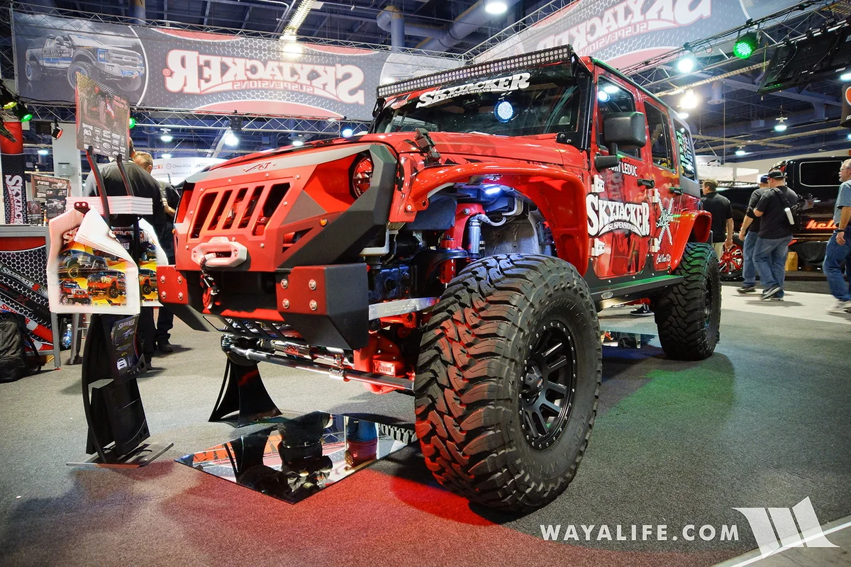 Red off-road Jeep with Skyjacker decals and convention display, credited to Wayalife